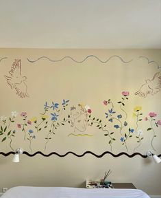 a bedroom with flowers and birds painted on the wall