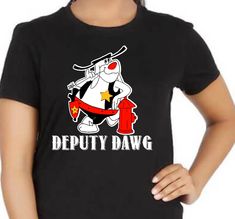 "Show off your love for classic cartoon characters in this Deputy Dawg t-shirt! Featuring Deputy Dawg, this is one tee that will show everyone your appreciation for classic 2D animation. What a perfect way to show your love for Deputy Dawg and the rest of his woodland friends!\" ALL SHIRTS ARE UNISEX SIZES REGARDLESS OF THE MODEL PICTURED 100% cotton preshrunk jersey knit Classic fit Seamless double needle 7/8\" collar Taped neck and shoulders Double needle sleeve and bottom hems Quarter-turned to eliminate center crease Tear away label Sizes: S-4XL, (5XL are special requests)" Funny Character Print T-shirt For Fan Conventions, Deputy Dawg, Classic Cartoon Characters, Woodland Friends, The Time Is Now, 2d Animation, Classic Cartoons, Model Pictures, Cartoon Characters