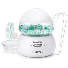 the beadalct machine is white and has green beads in it's bowl