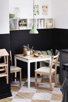 an image of a kitchen with black and white tile on the floor, table and chairs