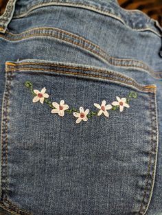 a pair of jeans with embroidered flowers on the back of it's butts