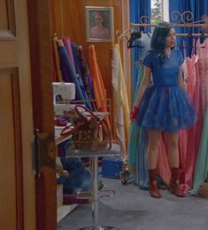 two women are looking at dresses in a closet, one is wearing a blue dress