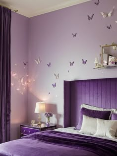 a bedroom decorated in purple and white with butterflies on the wall