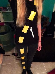 a woman with long blonde hair wearing a black shirt and yellow tape around her legs