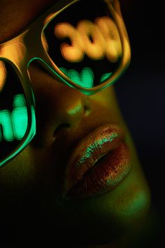 a woman wearing glasses with green light on her eyes