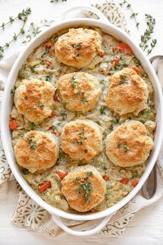 a casserole dish filled with biscuits and vegetables