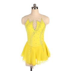 a yellow dress with sequins on the top and bottom, is sitting on a mannequin