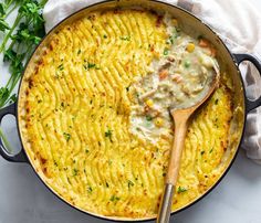 a skillet filled with macaroni and cheese on top of a white table