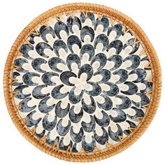 a black and white plate with an intricate design on the bottom, in a woven basket