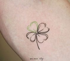 a small four leaf clover tattoo on the left thigh and right leg, with green ink