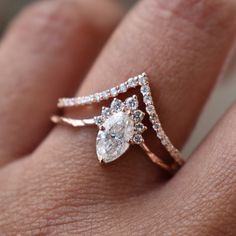 a woman's hand with a diamond ring on top of her finger and an engagement band