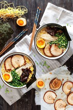 two bowls filled with food next to chopsticks on top of a wooden table