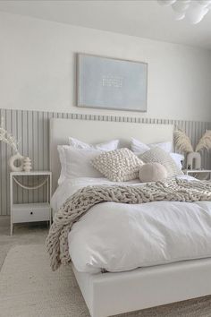 a white bed sitting in a bedroom next to a window