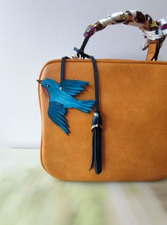 "Make a bag unique!! This bird bag charm with tassel is handmade from premium leather and hand painted with Blue bird design. The leather purse charm is just beautiful. This unique handmade leather charm would make a lovely gift for any bird lover. The leather bag charm could also be given as a little gift for a friend, sister or daughter! Completely handcrafted as the hand cut leather is hand-painted and hand-burnished. Width of leather bird approximately 3.8 inches (9.5 cm). Height of leather Bird Purse, Make A Bag, Eastern Bluebird, Key Charms, Handbag Charms, Gift For Daughter, Bird Lover, Purse Charms, Bird Design