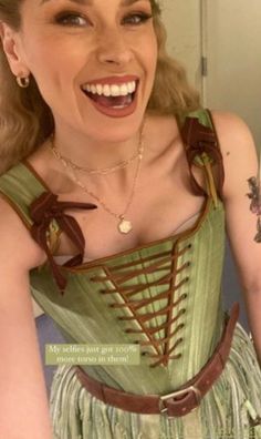 a woman wearing a green corset and smiling