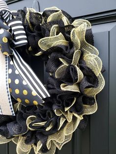 a black and gold wreath with polka dots on it hanging from the front door,