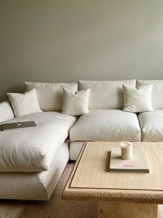 a living room with a couch, coffee table and laptop on top of the ottoman