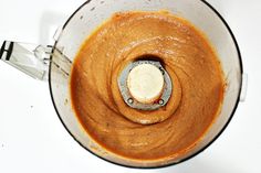 a blender filled with brown liquid on top of a white counter