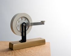 a clock that is sitting on top of a wooden table next to a piece of metal