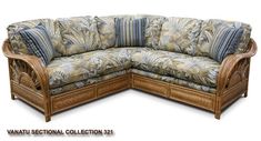 a large wooden sectional couch with blue and white pillows on it's back end