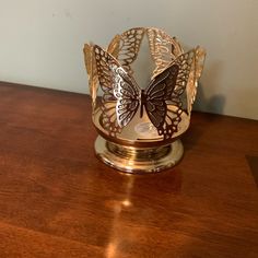 a gold butterfly crown sitting on top of a wooden table