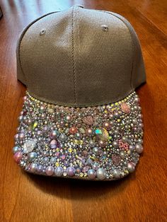 One-of-a-kind custom blinged-out ball cap style hat with a velcro strap on the back. There is an opening for a ponytail too. The pictures don't show how sparkly this hat is. It is grey with multi-colored jewels that hint at lavender, pink, and multi-faceted colors that are so vibrant when in the sun. Sassy and fun! Rhinestone Baseball Cap One Size, Adjustable Rhinestone Baseball Cap With Curved Brim, Rhinestone Embellished One Size Baseball Cap, Casual Adjustable Baseball Cap With Rhinestones, Trendy Rhinestone Adjustable Baseball Cap, Casual Snapback Baseball Cap With Rhinestones, Adjustable Rhinestone Cap, Rhinestone Baseball Cap, Bling Hat