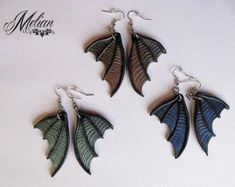 three pairs of earrings with leaves on them are shown in front of a white background