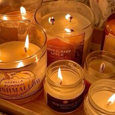 several candles are sitting on a tray next to each other