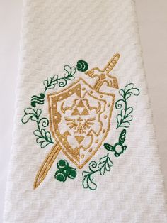 a white towel with green and gold embroidered on it