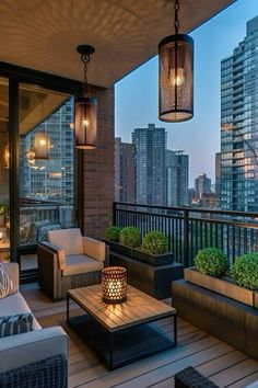 an outdoor living area with couches, tables and lamps on the balcony overlooking skyscrapers