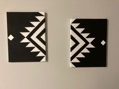 two pieces of black and white art hanging on the wall next to each other in a room