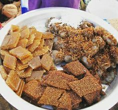 a white plate topped with lots of food on top of a wooden table next to a stuffed animal