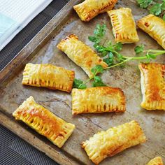 several pastries on a baking sheet with parsley