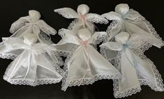 three white cloth angel ornaments with bows and lace