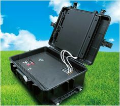 an open black box with wires in it on top of green grass and blue sky