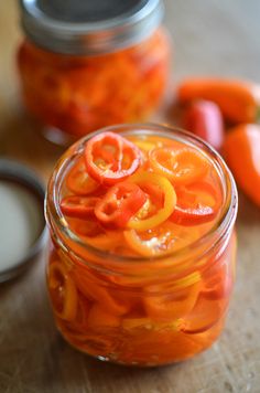 a jar filled with sliced oranges on top of a wooden table