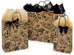 two brown paper bags with black bows and flowers on them