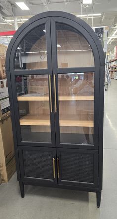 an empty display case in a store with other items on the shelves and boxes behind it