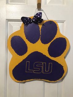 a purple and yellow dog paw with a bow on it's head hanging from a door