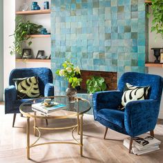 a living room with two blue chairs and a coffee table