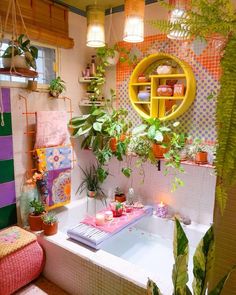 a bathtub with plants and candles in it next to a potted plant on the wall