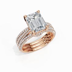 an emerald and diamond ring set with two rows of diamonds on each band, in 18k rose gold