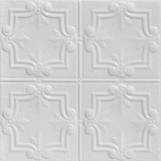 a white ceiling tile with four different designs on the wall and one is made out of ceramic