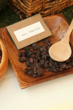 some raisins and a wooden spoon on a table