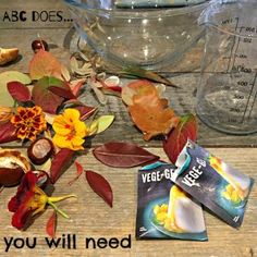 there is a bowl with flowers and leaves next to some candy bars on the table