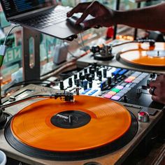 a dj mixing music with an orange record player