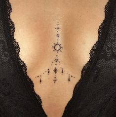 a woman's chest with an arrow and stars tattoo on her left side ribcage