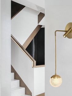 a white room with stairs and a gold light fixture