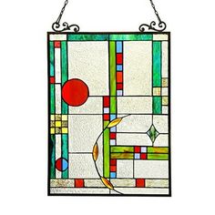 a colorful stained glass window hanging on a metal chain, with an abstract design in the center