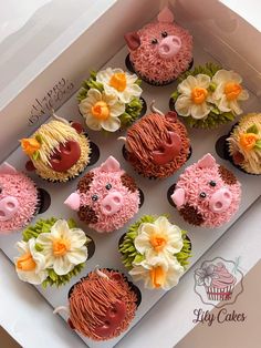 cupcakes decorated with pink icing and flowers in a box